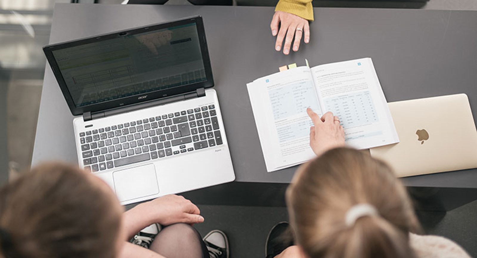 Laptop and book laying on the grey table