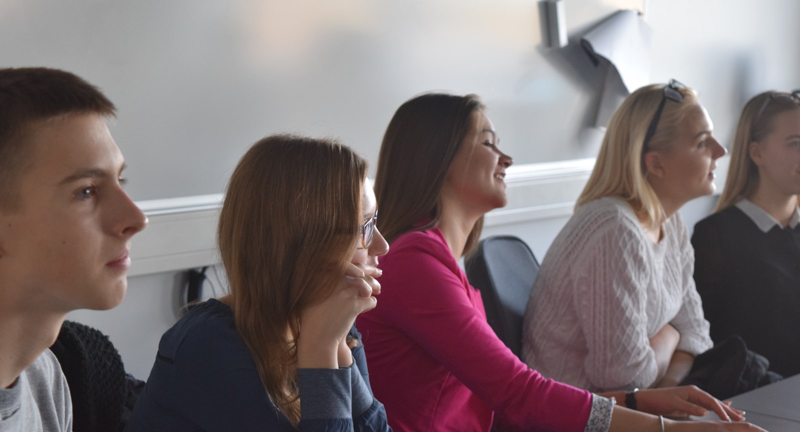 Students sitting next to the blackboard in class room