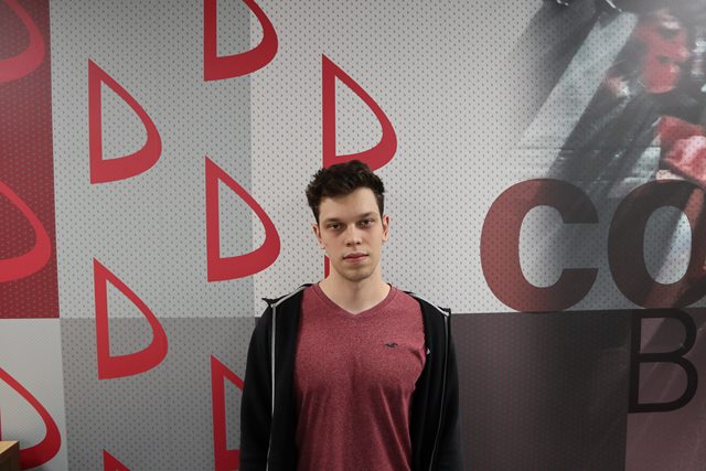 Young student standing on the wall with Dania Academy logo