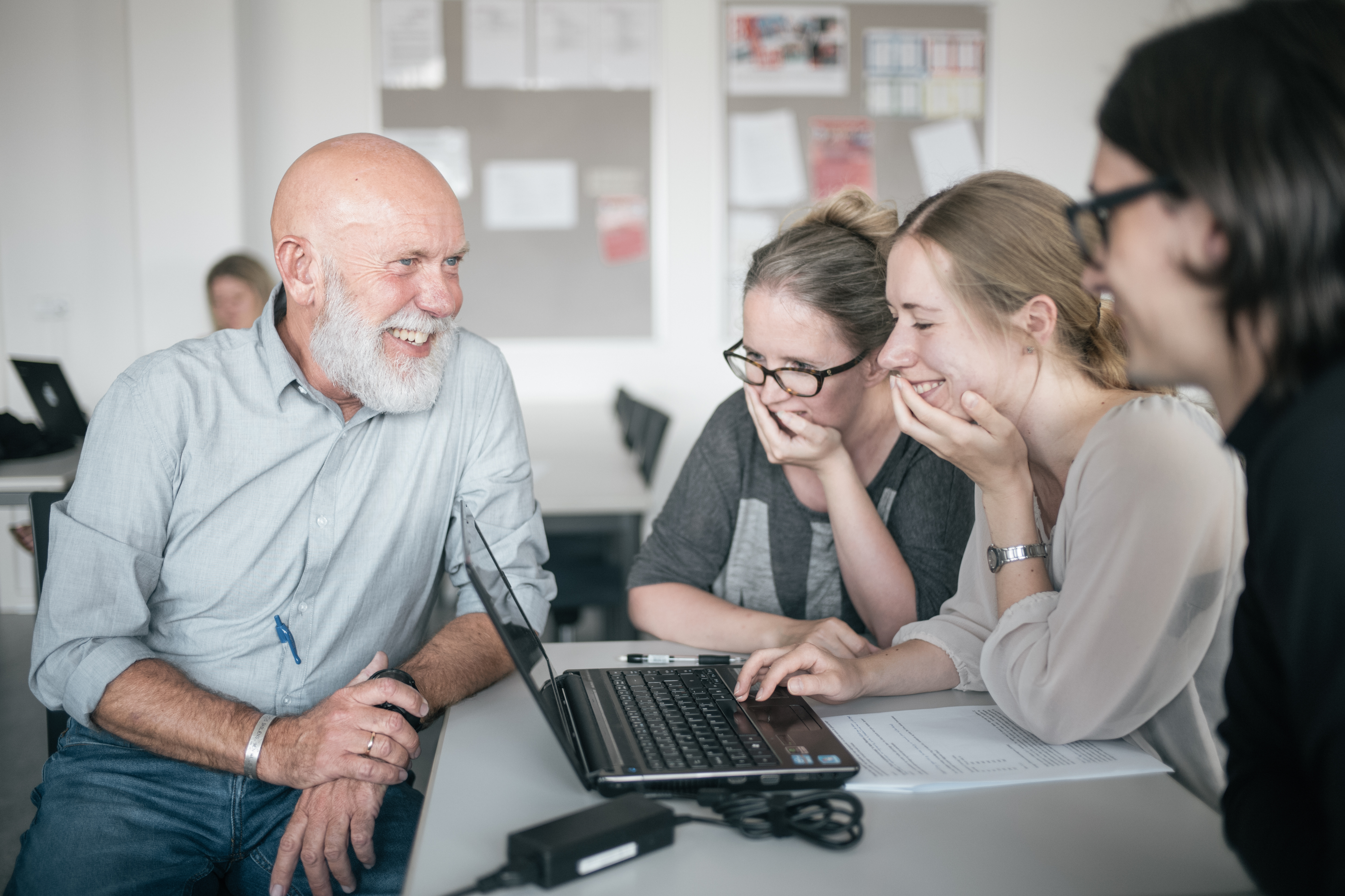 Underviser taler med de studerende, mens alle smiler.