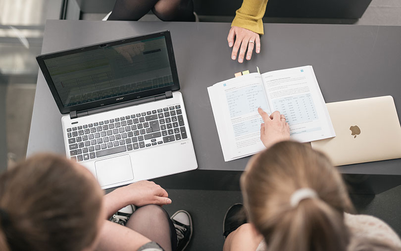 Laptop and book laying on the grey table