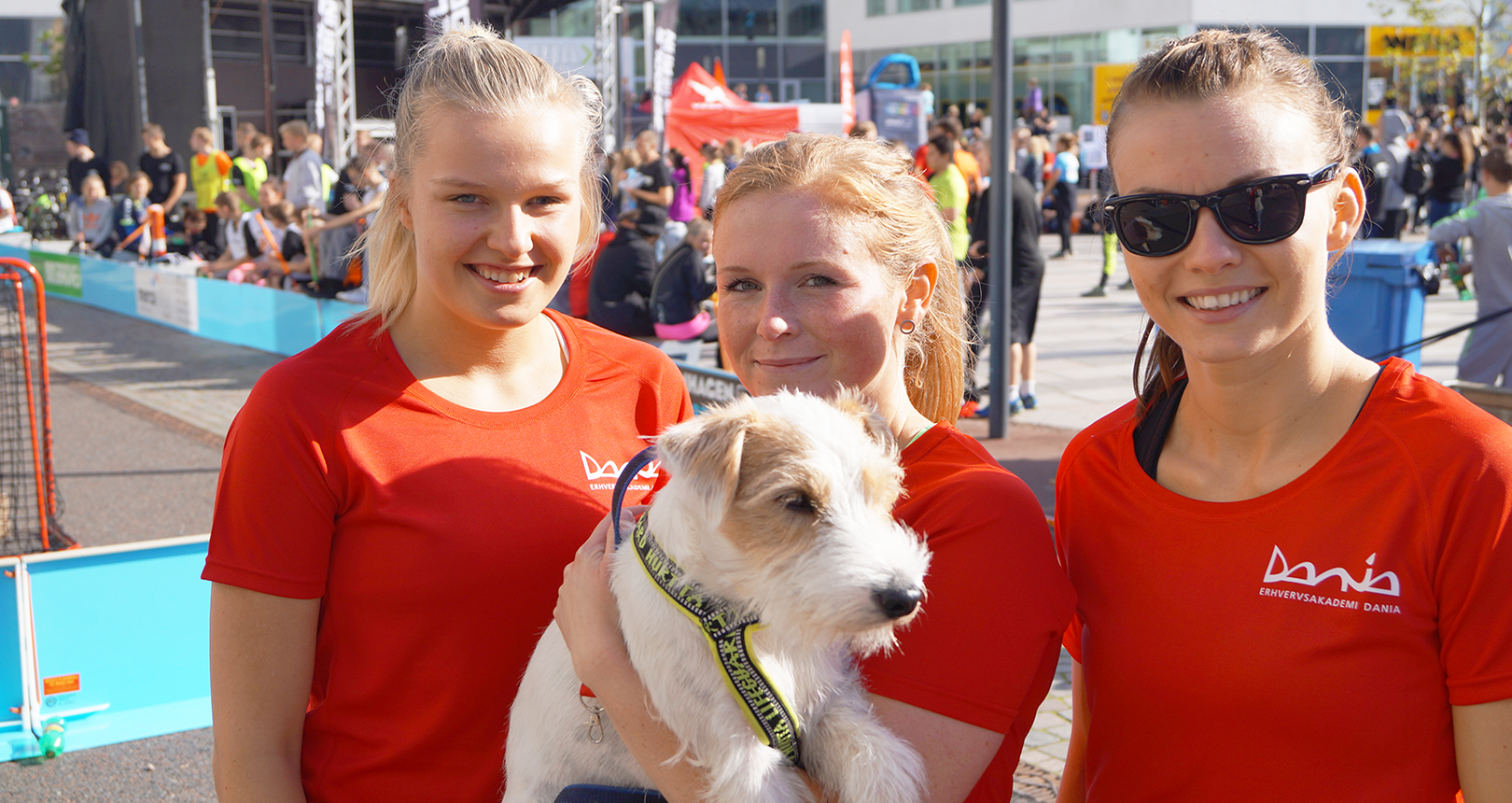 Three women in Dania's t-shirts holding the dog