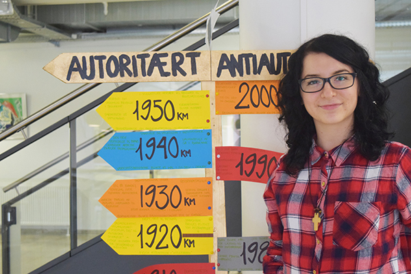 Student standing in the school next to the stairs