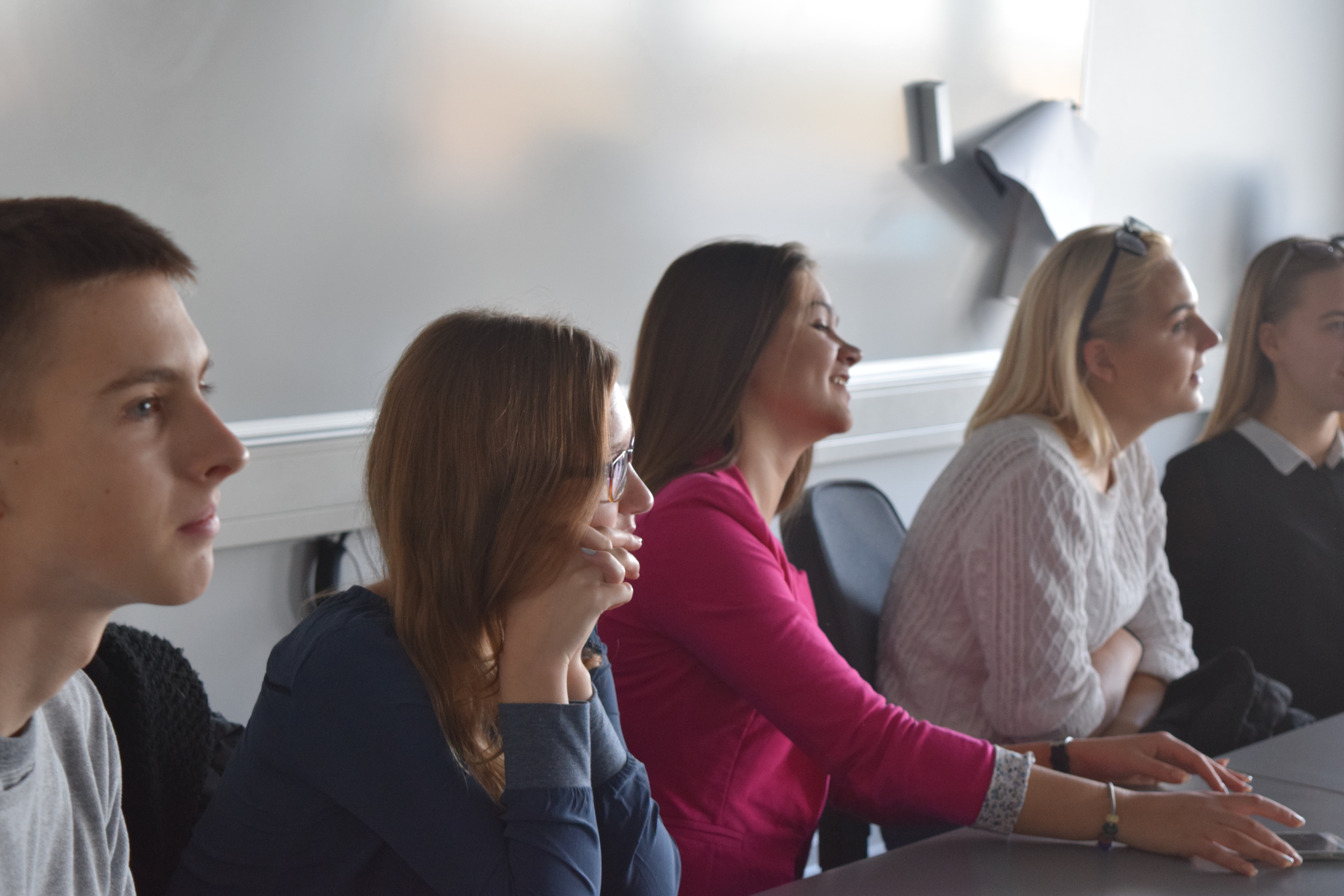 Students sitting next to the blackboard in class room