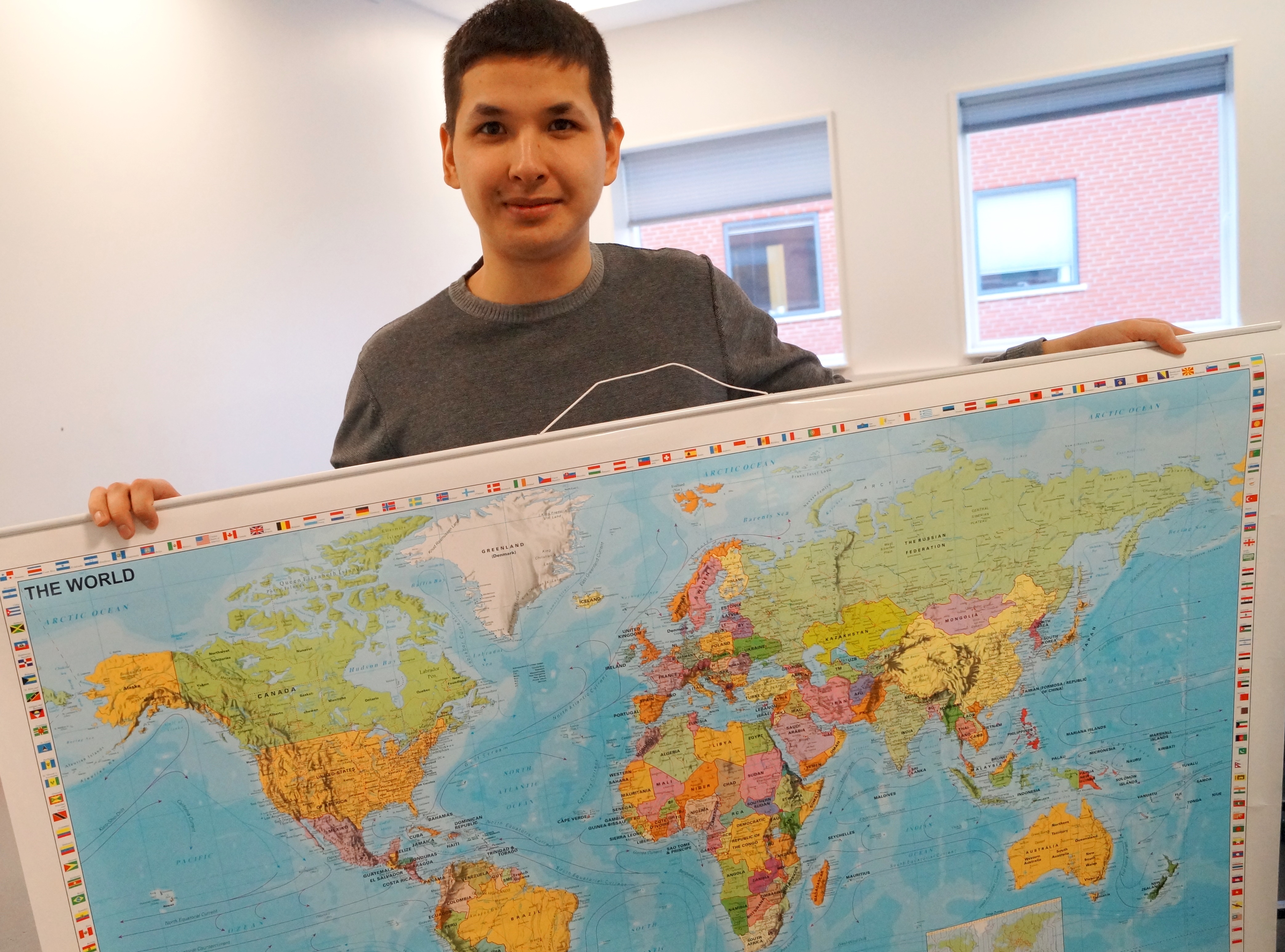 Student holding map of the world