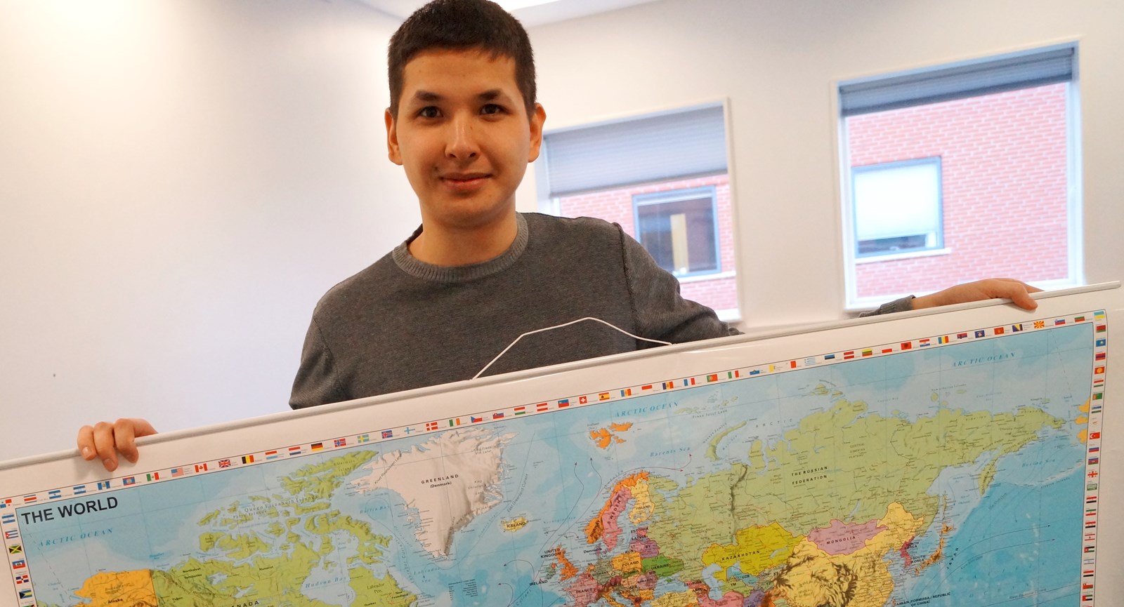 Student holding map of the world