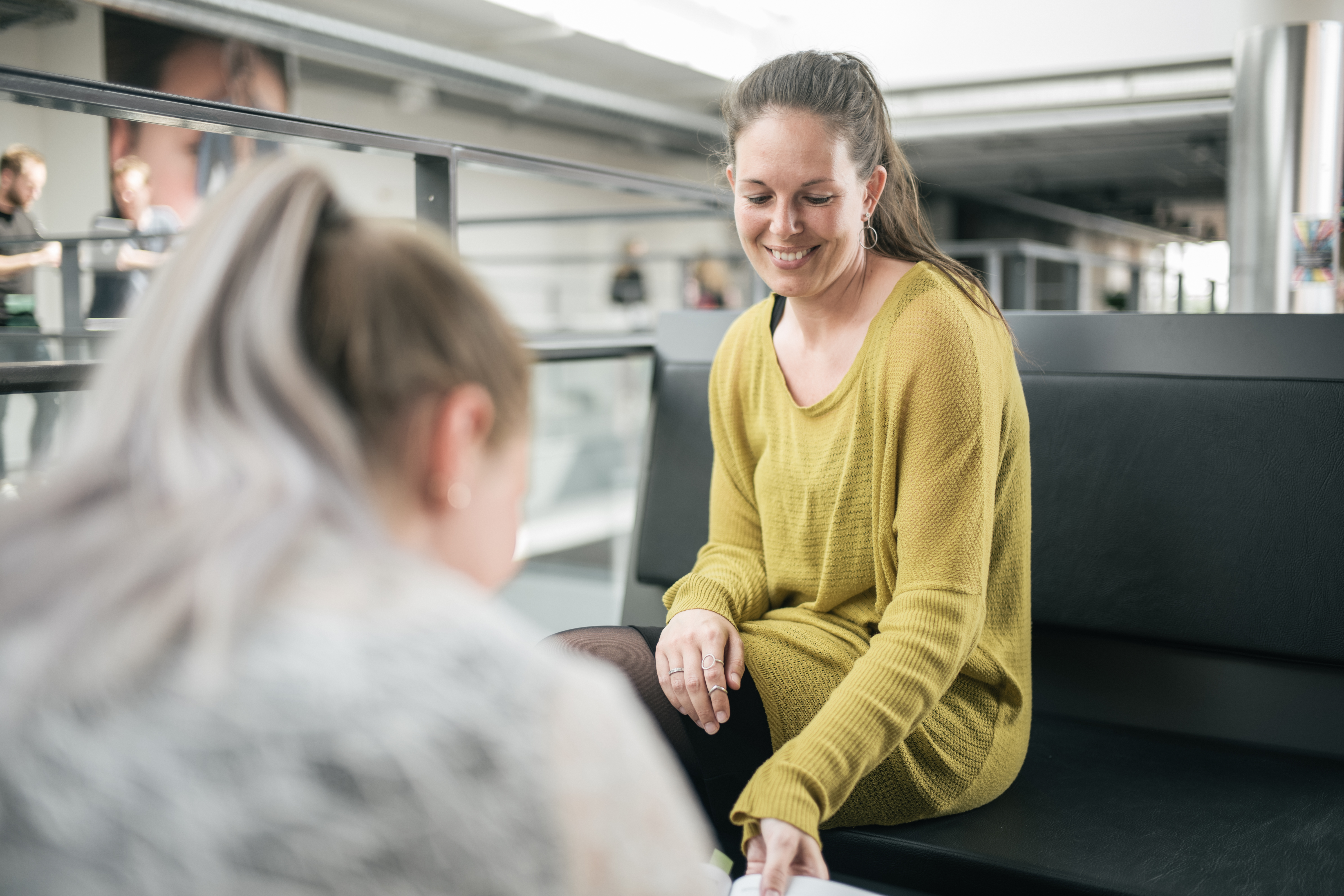 Women in the yellow sweater helping her friend with tasks