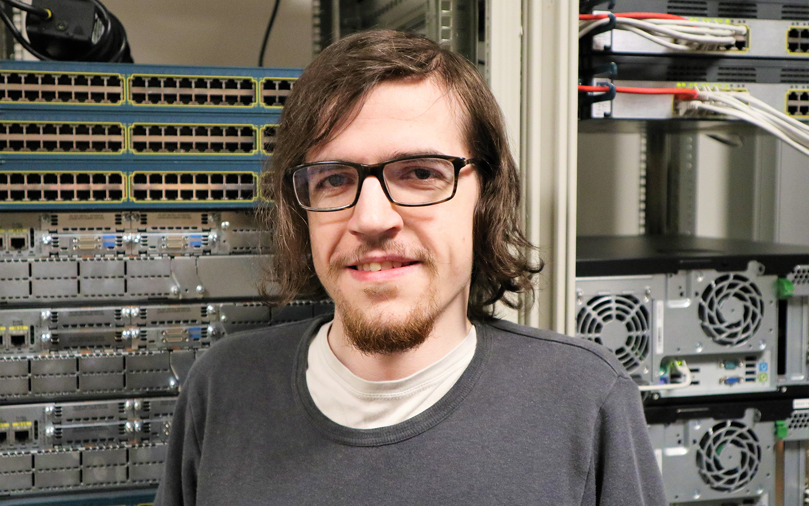 It-teknolog Joan med briller og halvlangt hår foran servere og andet it-udstyr