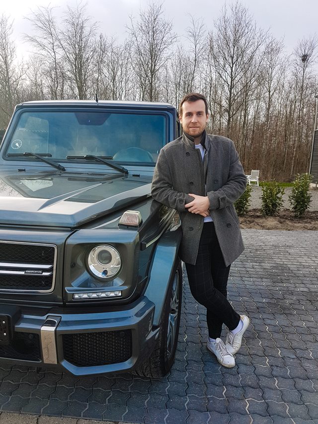 Student standing next to new car