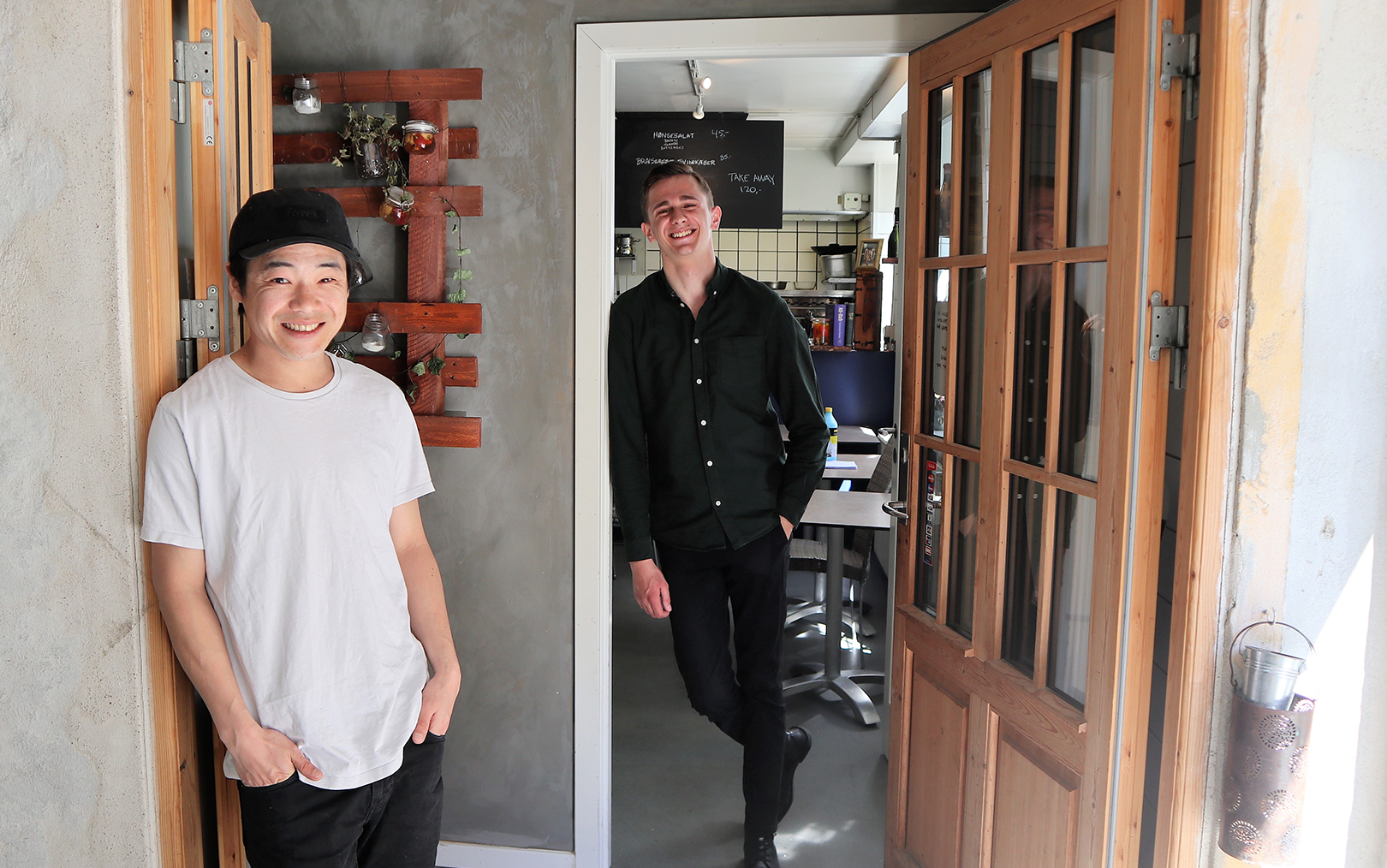 Two students standing in front of the door and smiling